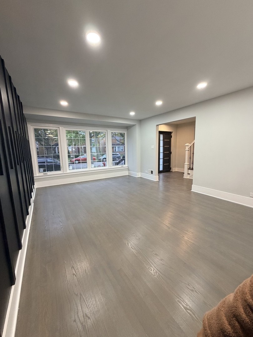 3024 West Fargo Avenue Chicago, IL 60645 - Photo 9 of 38 an empty room with large windows and wooden floor