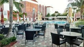 a view of an outside dining space with furniture and a fire pit