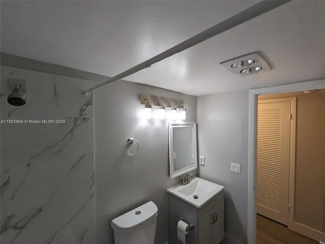 a bathroom with a toilet a sink and mirror