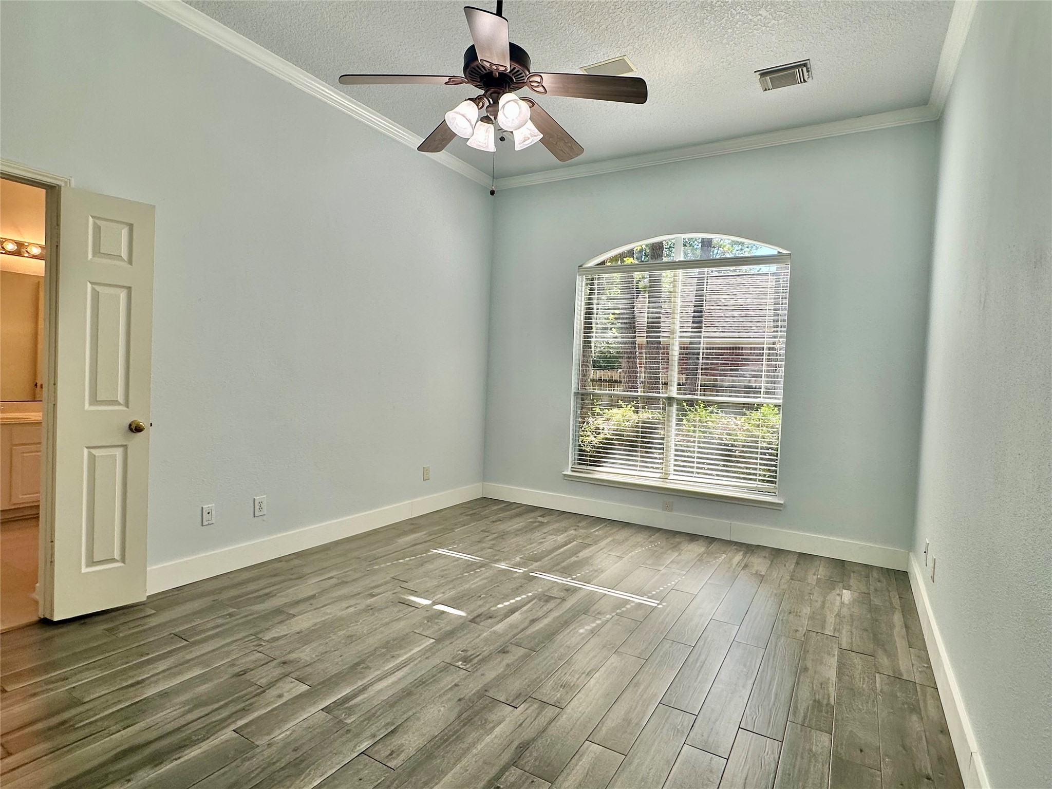 18 South Willow Point Circle Spring, TX 77382 - Photo 10 of 27 an empty room with wooden floor chandelier fan and windows