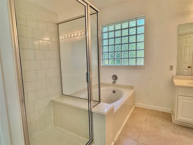 a bathroom with a tub sink and mirror