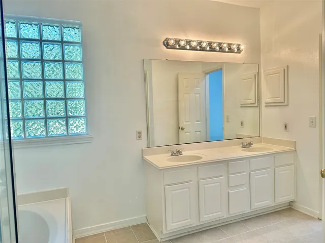 a bathroom with a tub shower and window
