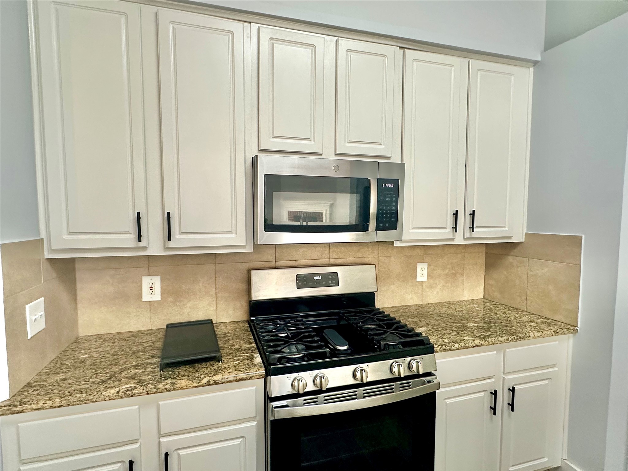 18 South Willow Point Circle Spring, TX 77382 - Photo 5 of 27 a kitchen with granite countertop white cabinets and stainless steel appliances