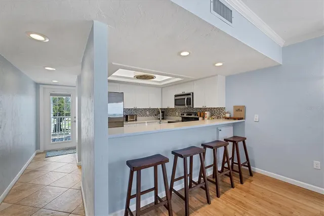 a bedroom with a bed a chandelier and a dresser