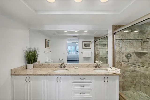 a bathroom with a granite countertop sink toilet and shower