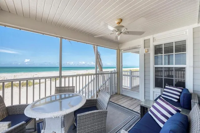 a living room with furniture a ceiling fan and a large window