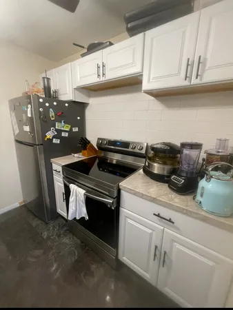 a kitchen with stainless steel appliances granite countertop a refrigerator and a stove