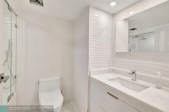a bathroom with a bathtub shower sink vanity and toilet