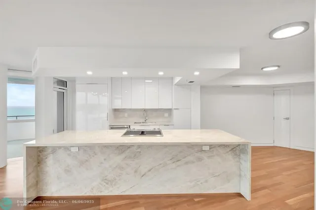 a large kitchen with kitchen island a stove a center island and a refrigerator