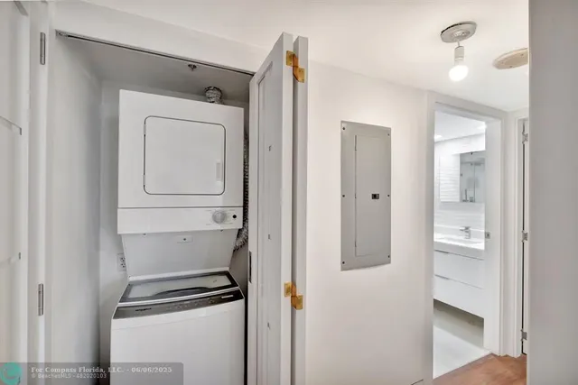 a living room with furniture large windows a rug and white walls