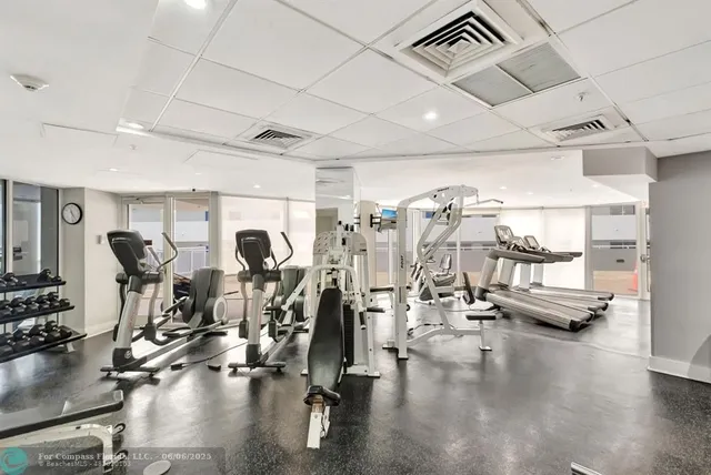 a view of a patio with a table and chairs under an umbrella with a small yard