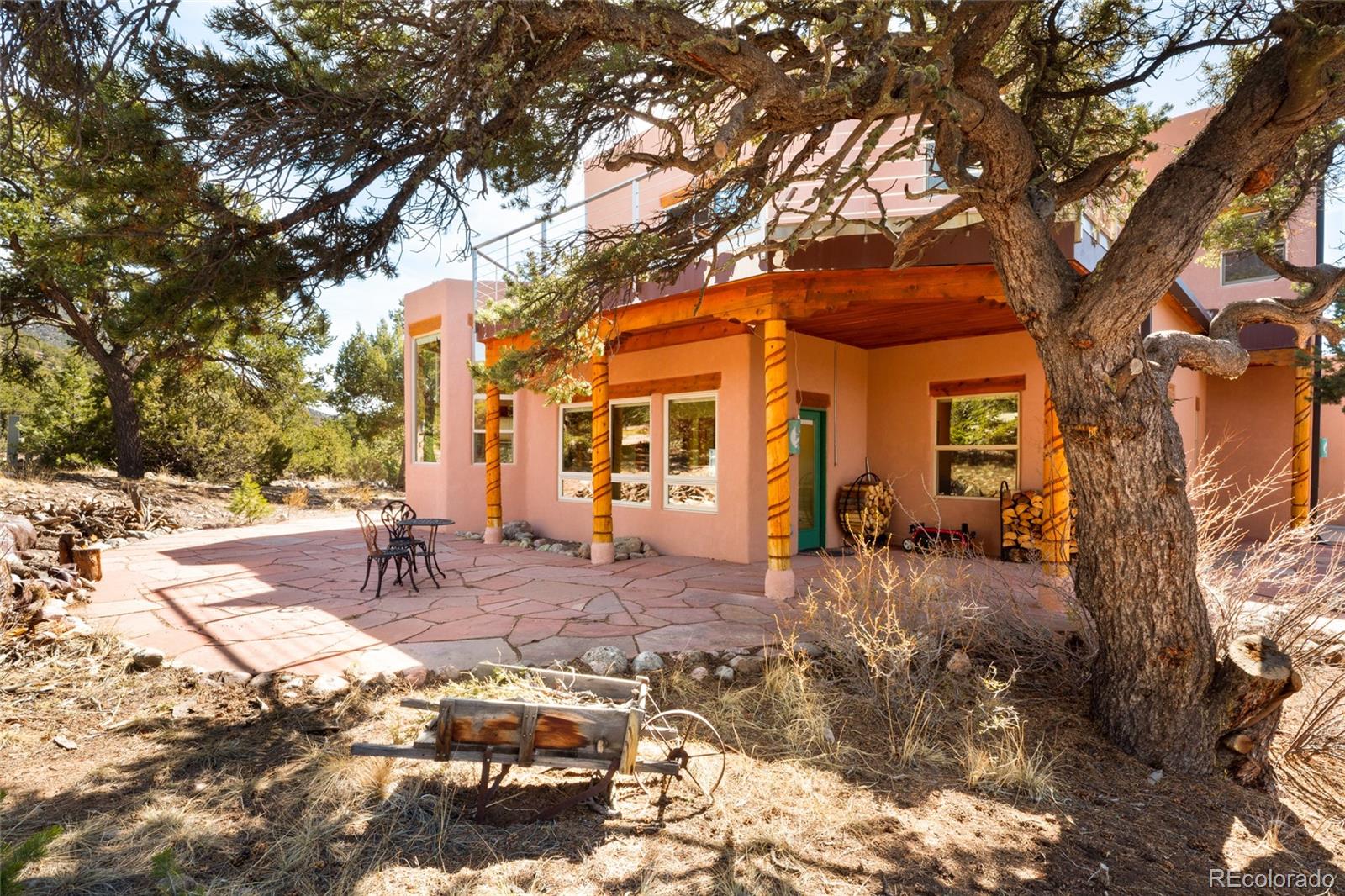 1329 Moonlight Way Crestone, CO 81131 - Photo 43 of 50 a backyard of a house with table and chairs under a large tree