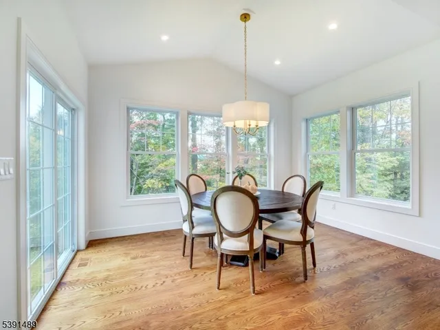 a dining room with furniture a chandelier and wooden floor