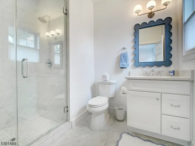 a bathroom with a sink toilet vanity and shower