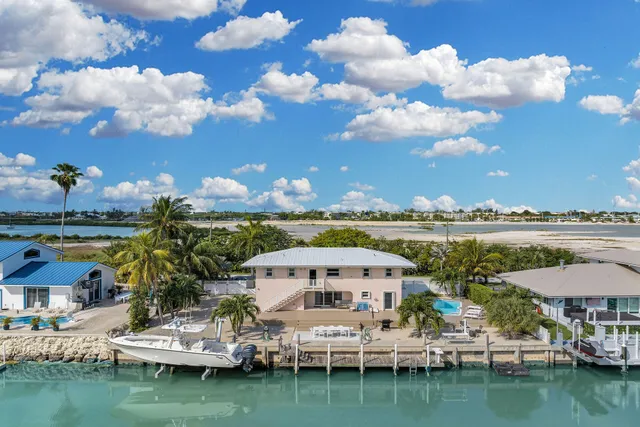 a kitchen with stainless steel appliances kitchen island granite countertop a dining table chairs and white cabinets