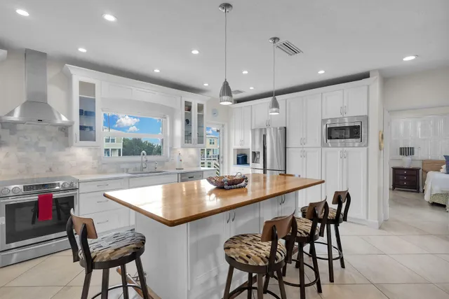 a kitchen with stainless steel appliances granite countertop a sink and a refrigerator