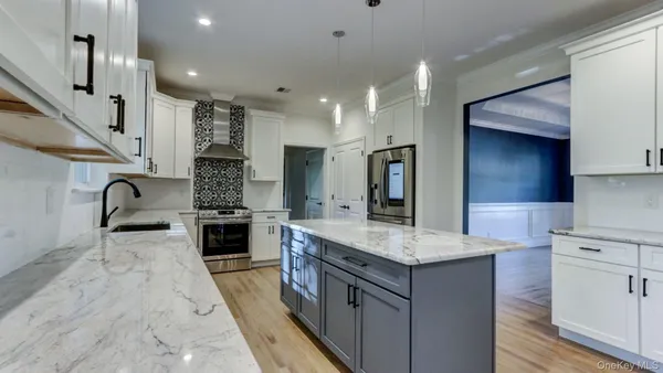 a kitchen with stainless steel appliances granite countertop a sink a stove and a refrigerator
