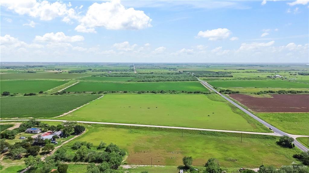 1/2 Farm To Market 506 Santa Rosa, TX 78593 - Photo 5 of 7 Expansive agricultural land featuring a clear blue sky with scattered clouds, multiple cultivated fields, and a paved road dissecting the landscape