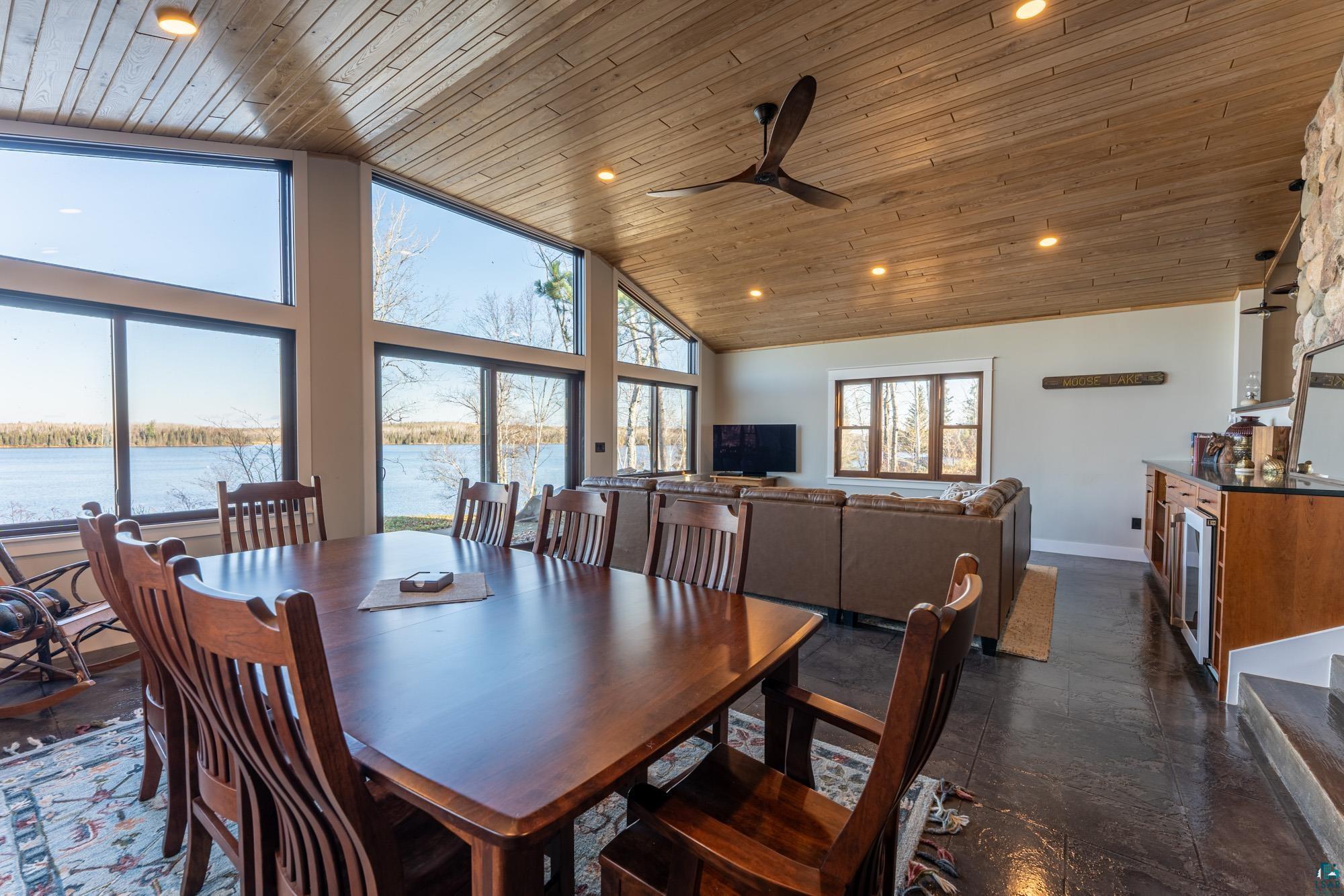 14635 Canadian Border Road Ely, MN 55731 - Photo 47 of 94 Vaulted wood-paneled ceiling, expansive window wall, recessed lighting, ceiling fan, and built-in wet bar with under-counter refrigeration