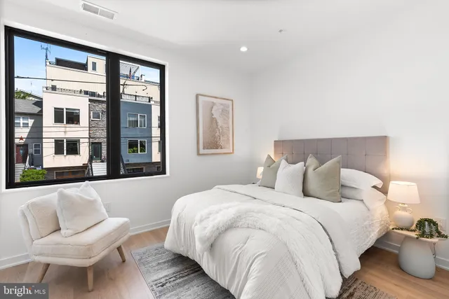 a bedroom with bed and wooden floor
