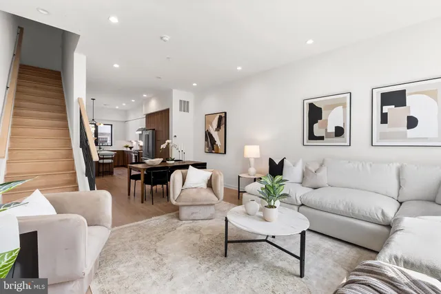 a living room with furniture and view of kitchen