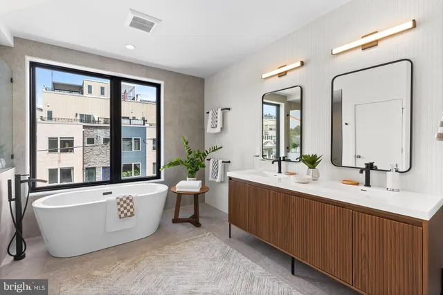 a large spacious bathroom with double vanity sinks a large mirror and a bathtub