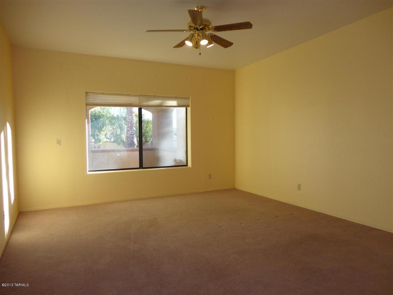 1429 North Bank Swallow Road Green Valley, AZ 85614 - Photo 9 of 34 an empty room with a window and a ceiling fan