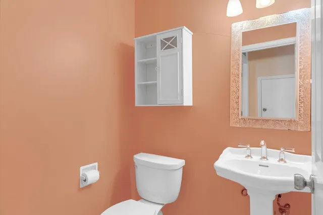 a bathroom with a toilet sink and mirror