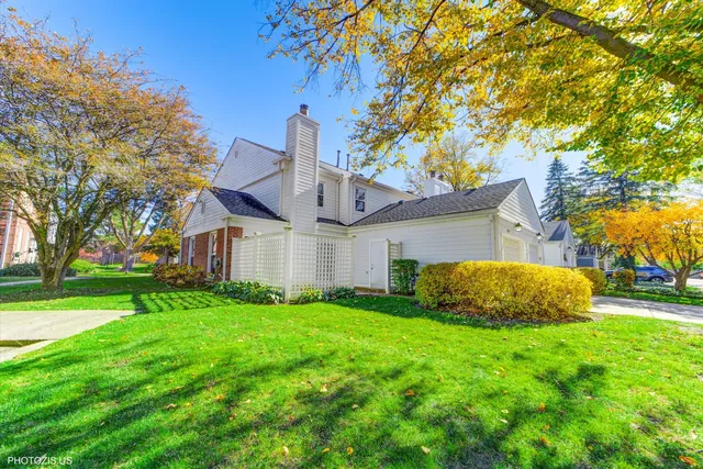 a view of a big house with a big yard and large trees