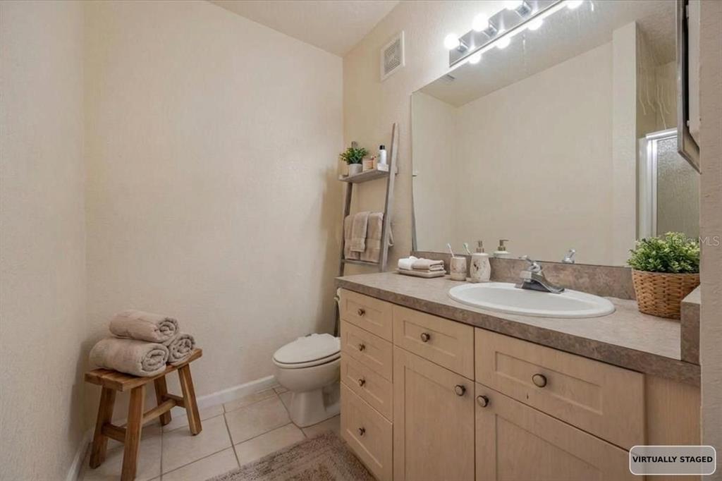 830 Airport Road, Unit 111 Port Orange, FL 32128 - Photo 9 of 21 a bathroom with a granite countertop sink a toilet and a mirror