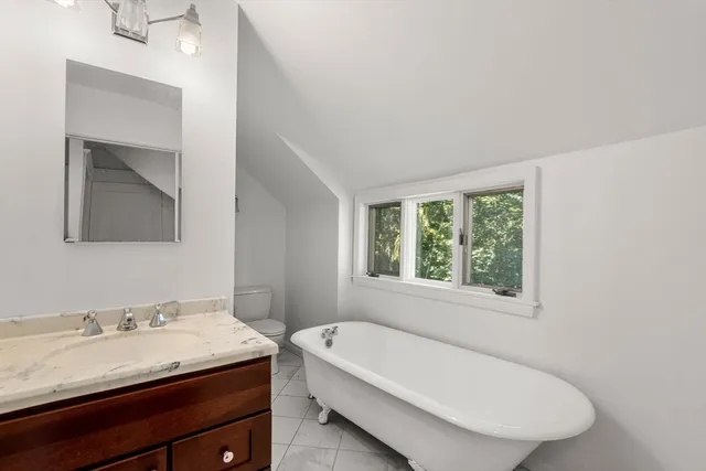 a bathroom with a granite countertop sink a toilet and mirror