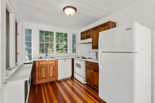 a kitchen with stainless steel appliances granite countertop a refrigerator a sink and white cabinets