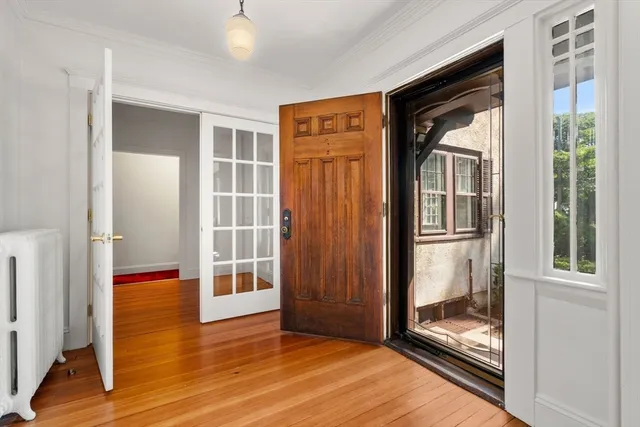 a view of empty room with wooden floor and floor to ceiling window