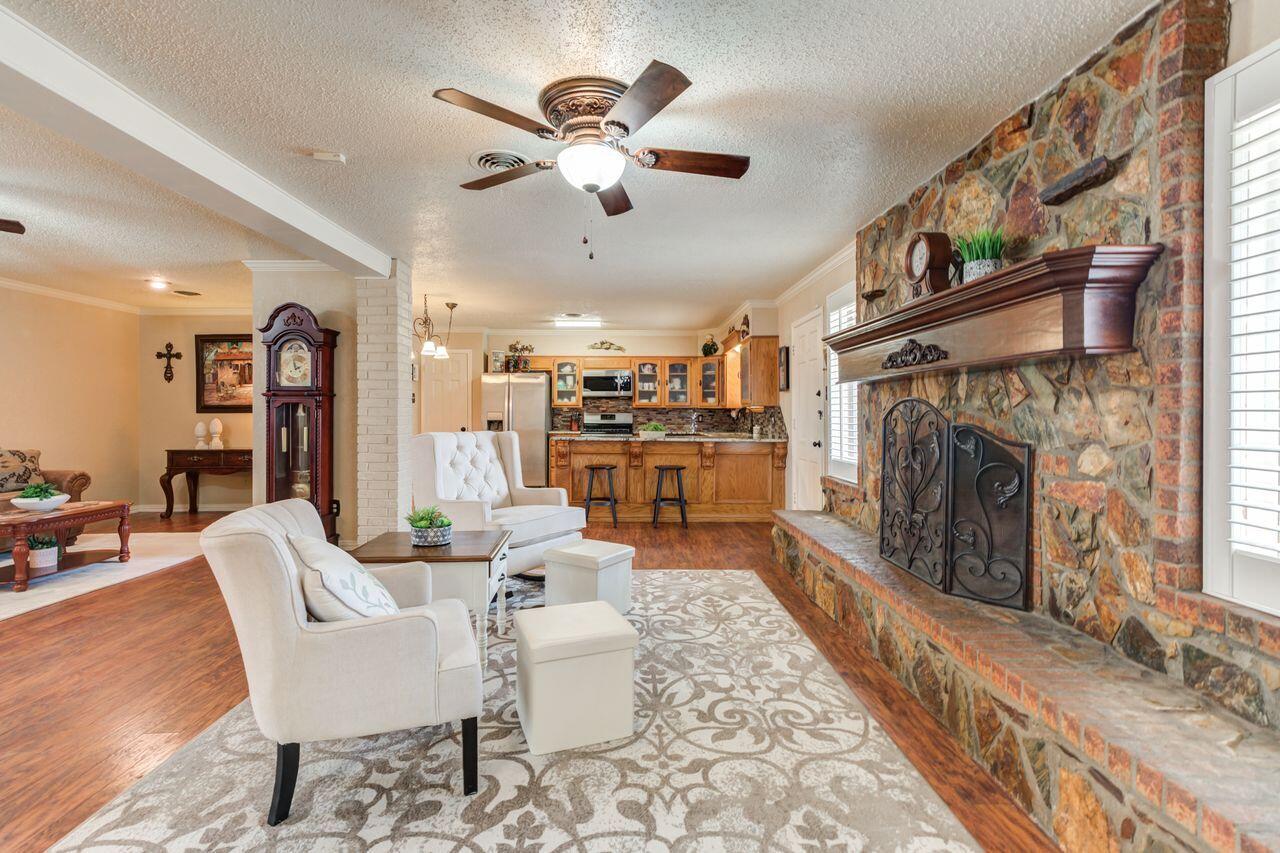 4904 18th Street Lubbock, TX 79416 - Photo 12 of 39 a living room with furniture a fireplace and a chandelier