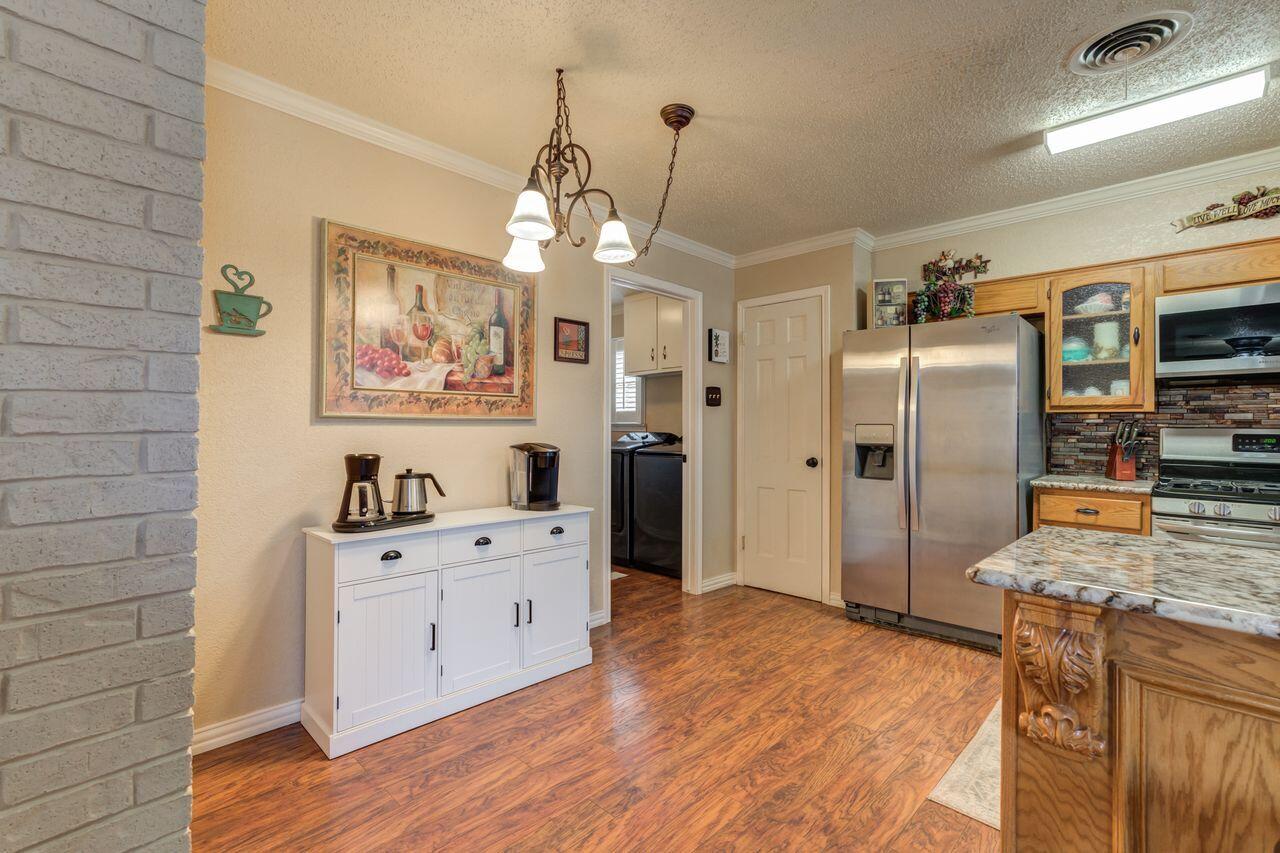 4904 18th Street Lubbock, TX 79416 - Photo 17 of 39 a kitchen with stainless steel appliances granite countertop a refrigerator a stove and a wooden floors