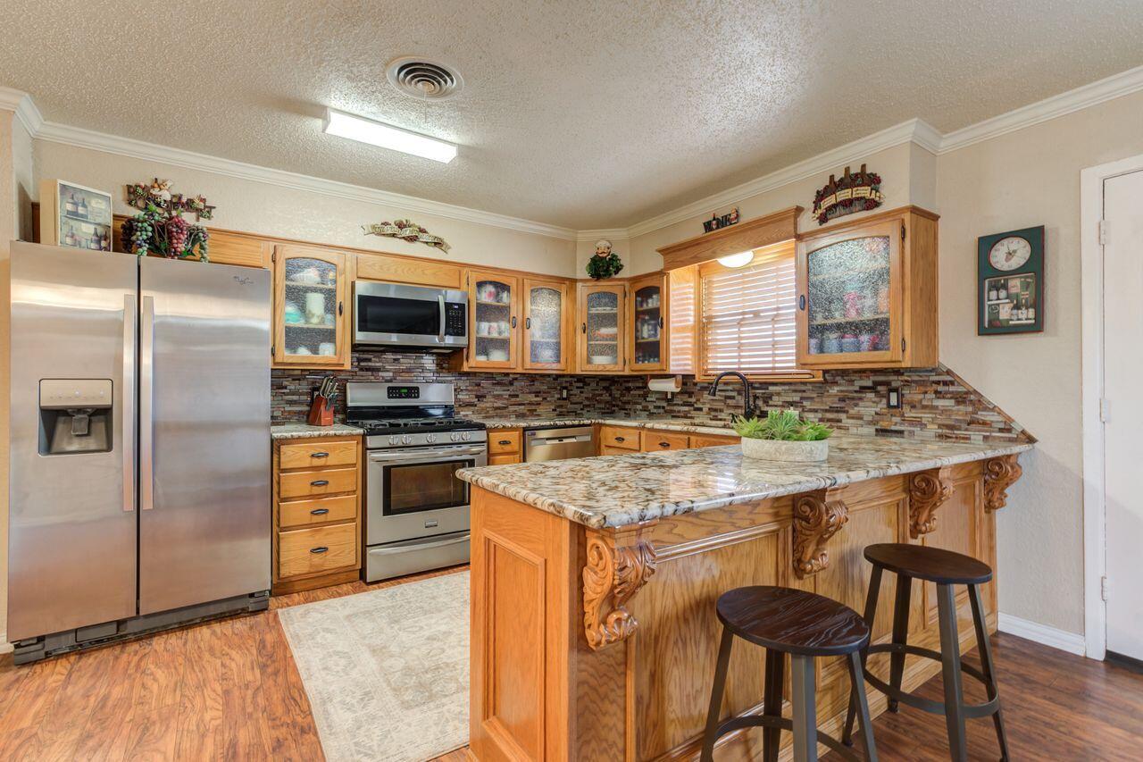 4904 18th Street Lubbock, TX 79416 - Photo 18 of 39 a kitchen with stainless steel appliances granite countertop a stove refrigerator sink and microwave