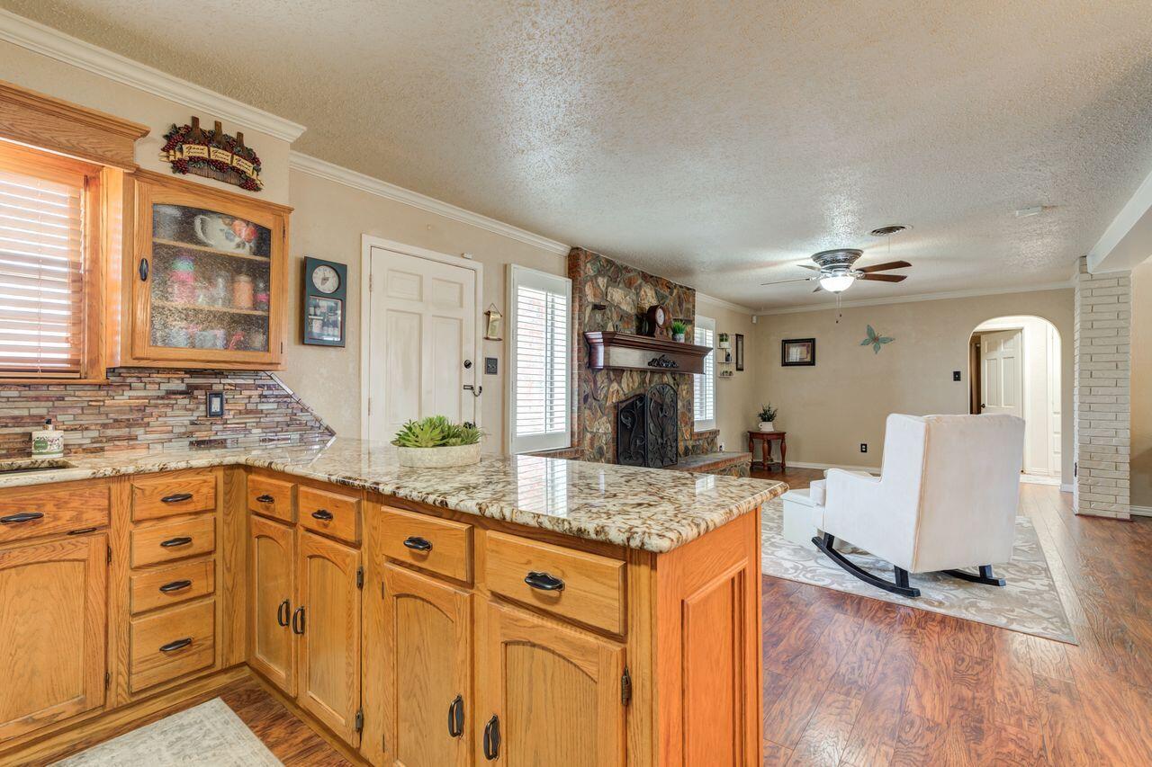 4904 18th Street Lubbock, TX 79416 - Photo 21 of 39 a kitchen with stainless steel appliances granite countertop a sink dishwasher and a stove with wooden floor