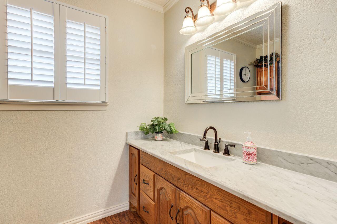 4904 18th Street Lubbock, TX 79416 - Photo 33 of 39 a bathroom with a sink and a mirror