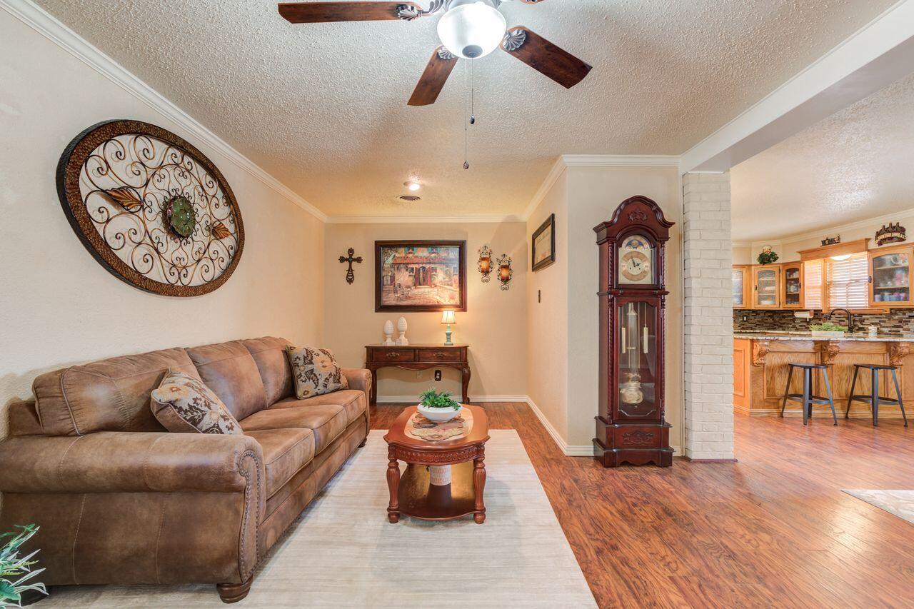 4904 18th Street Lubbock, TX 79416 - Photo 5 of 39 a living room with furniture a clock and a chandelier