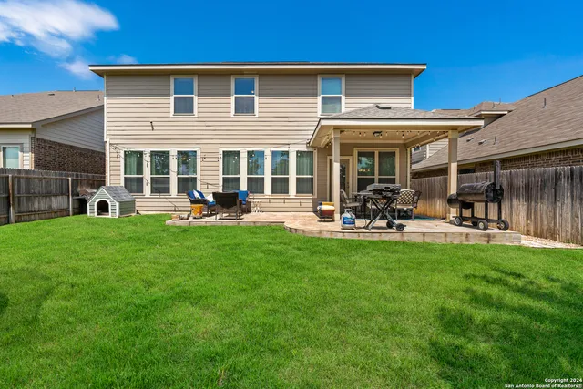 a view of patio with table and chairs potted plants and floor to ceiling window