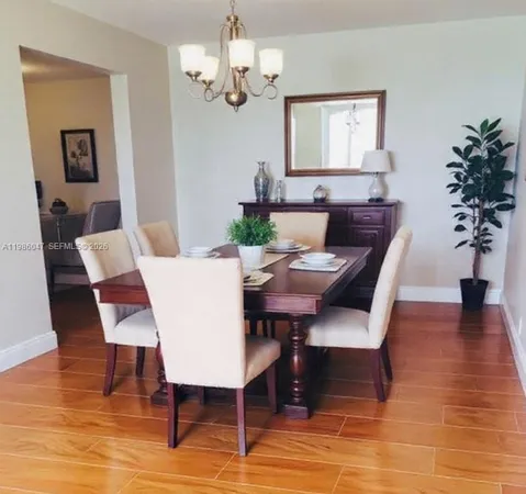 a view of a dining room with furniture a chandelier and wooden floor