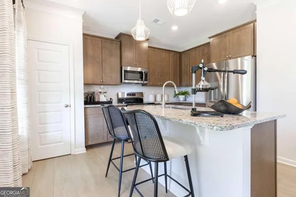 a kitchen with stainless steel appliances granite countertop a sink refrigerator and cabinets