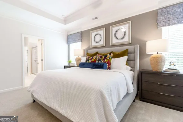 a bedroom with a bed and painting on the wall