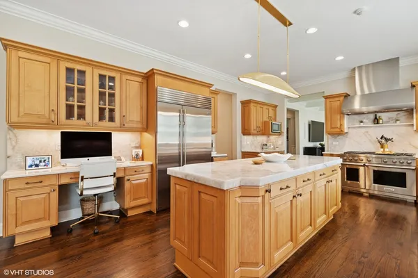 a kitchen that has a lot of cabinets in it wooden floors and a view of living room