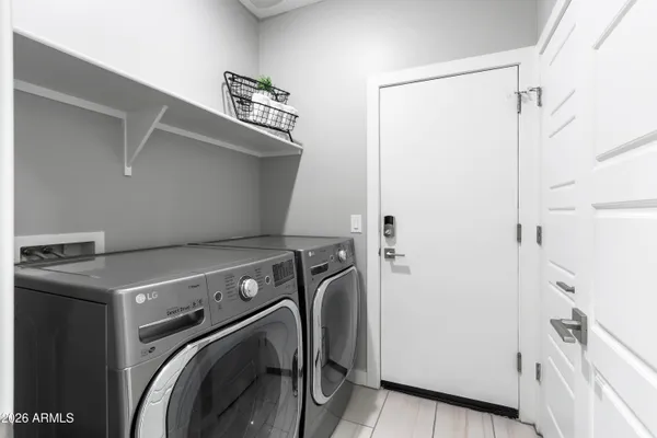 a living room with furniture white walls and kitchen view