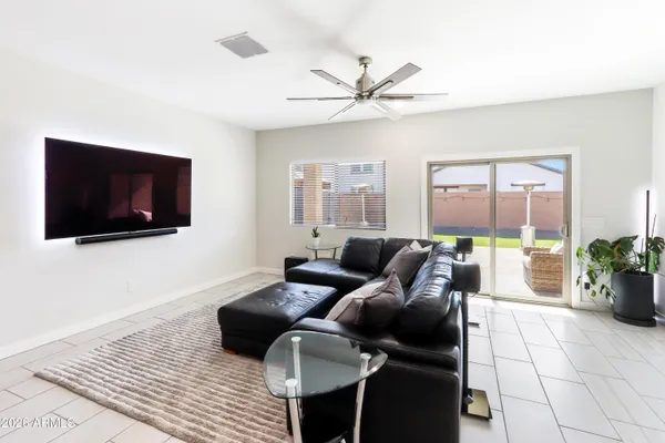 a living room with furniture a flat screen tv and a floor to ceiling window