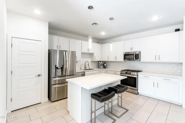 a kitchen with stainless steel appliances a stove refrigerator sink and cabinets