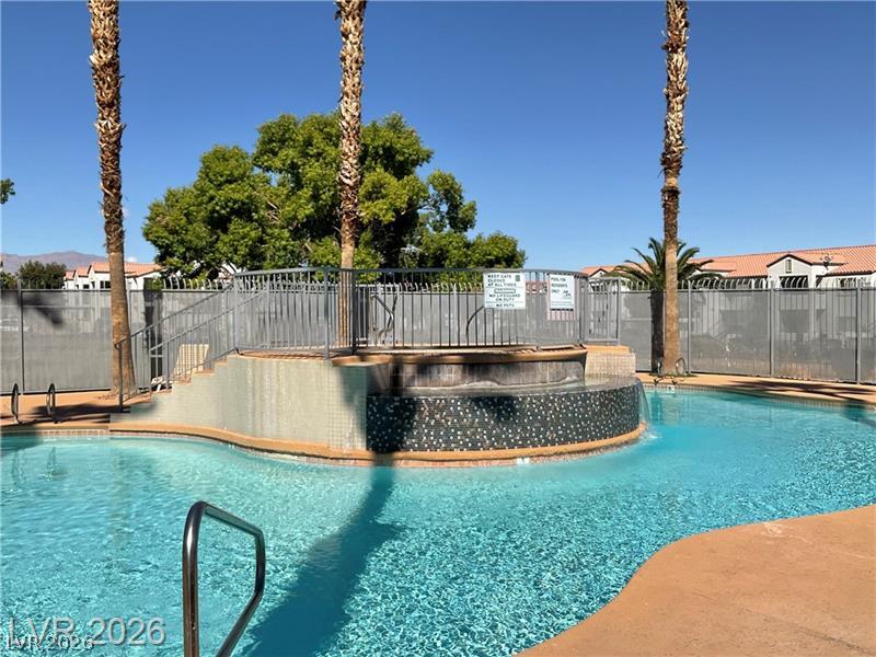 3318 North Decatur Boulevard, Unit 2152 Las Vegas, NV 89130 - Photo 37 of 58 An inviting swimming pool and spa area awaits under towering palm trees.