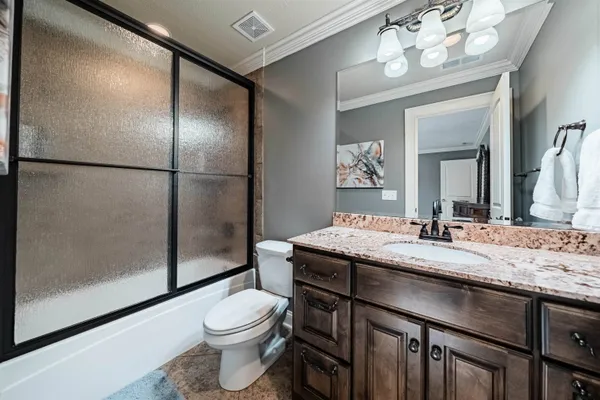 a bathroom with a granite countertop toilet a sink and a mirror