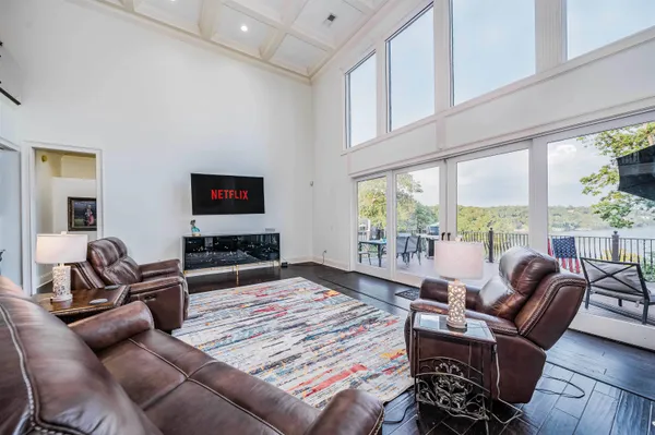 a living room with furniture flat screen tv and a large window